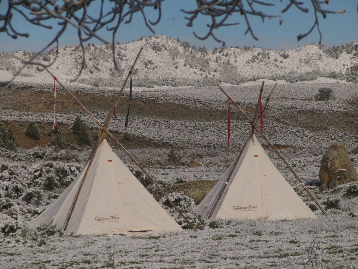 Two Cowboy Tipis pitched with external poles on a snowy ridge