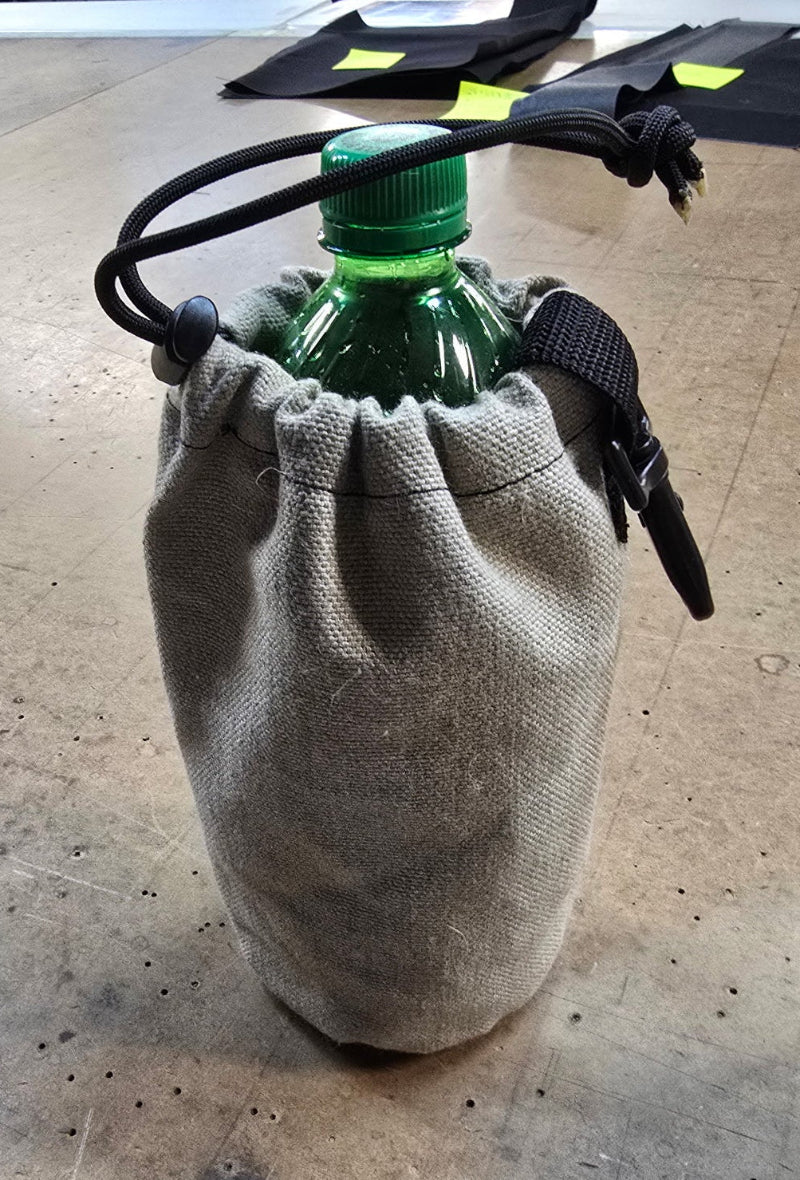 Canvas drawstring bottle carrier holding a green plastic bottle, with a clip on the side.