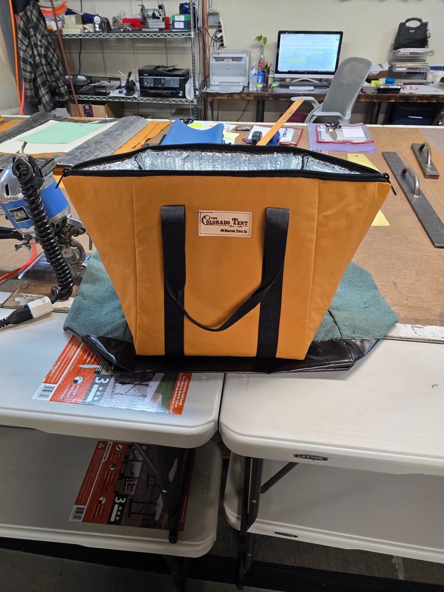 Tan insulated tote with a foil-lined interior, black web handles, and a Colorado Tent label.