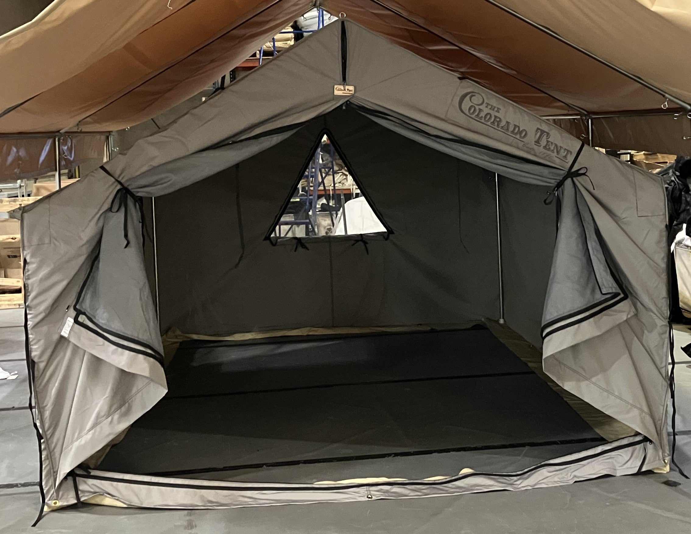Open canvas lodge tent with triangular window and Colorado Tent logo