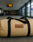Tan canvas duffel bag with black straps and Colorado Tent leather logo