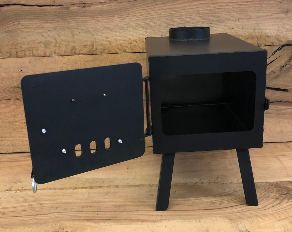 Base Camp Wood Stove by North Woods Fabrication, door open to the firebox