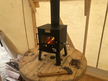 Mini Woodsman Wood Stove by North Woods Fabrication, burning in a canvas wall tent
