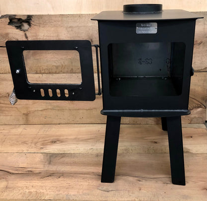 Woodsman Wood Stove by North Woods Fabrication, door open to the firebox