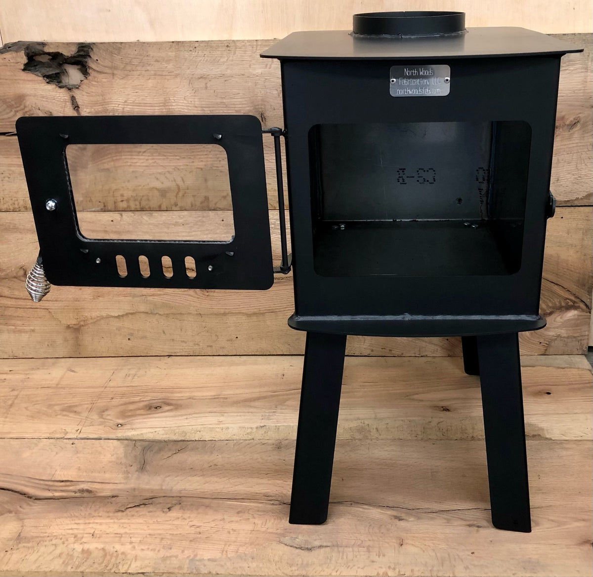 Woodsman Stove Kit by North Woods Fabrication, door open to the firebox