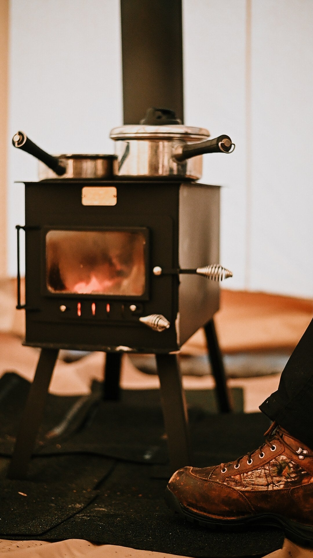 Woodsman XL Wood Stove by North Woods Fabrication, cooking on top inside a canvas tent