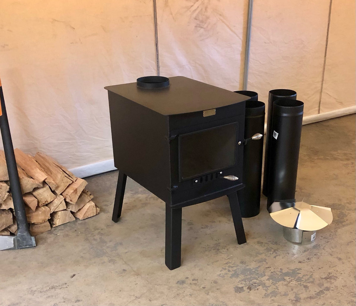 Woodsman XXL Stove Kit by North Woods Fabrication, three-quarter view with stove pipe and rain cap