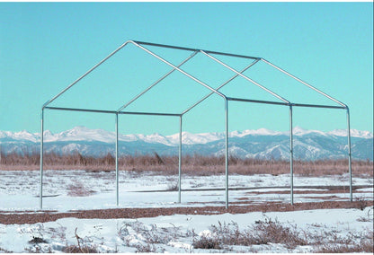 Bare galvanized steel tent frame standing in a snowy field with a mountain range behind it.
